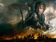 Bilbo, Gandalf, Thorin, and Smaug above the battlefield in featured art for The Hobbit: The Battle of the Five Armies